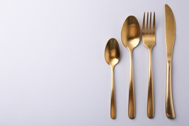 Photo of Stylish cutlery set on grey table, flat lay. Space for text