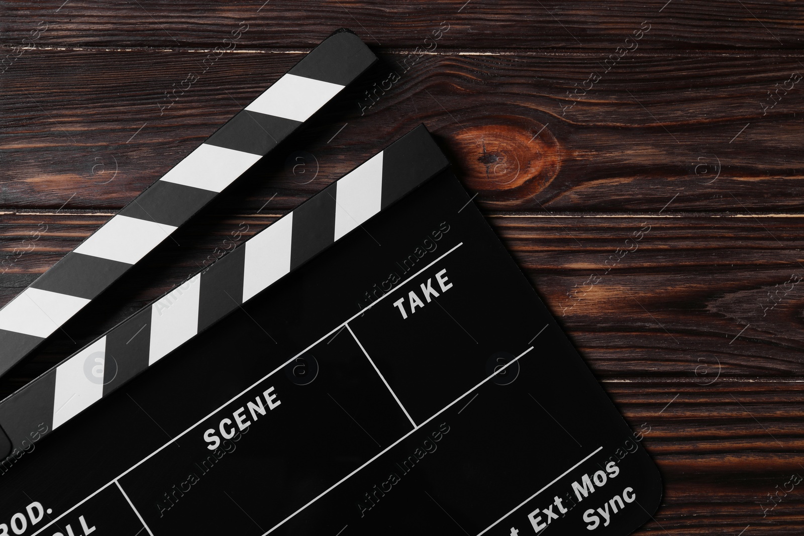 Photo of Clapperboard on wooden table, top view. Space for text