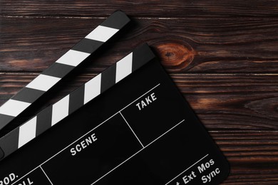 Clapperboard on wooden table, top view. Space for text