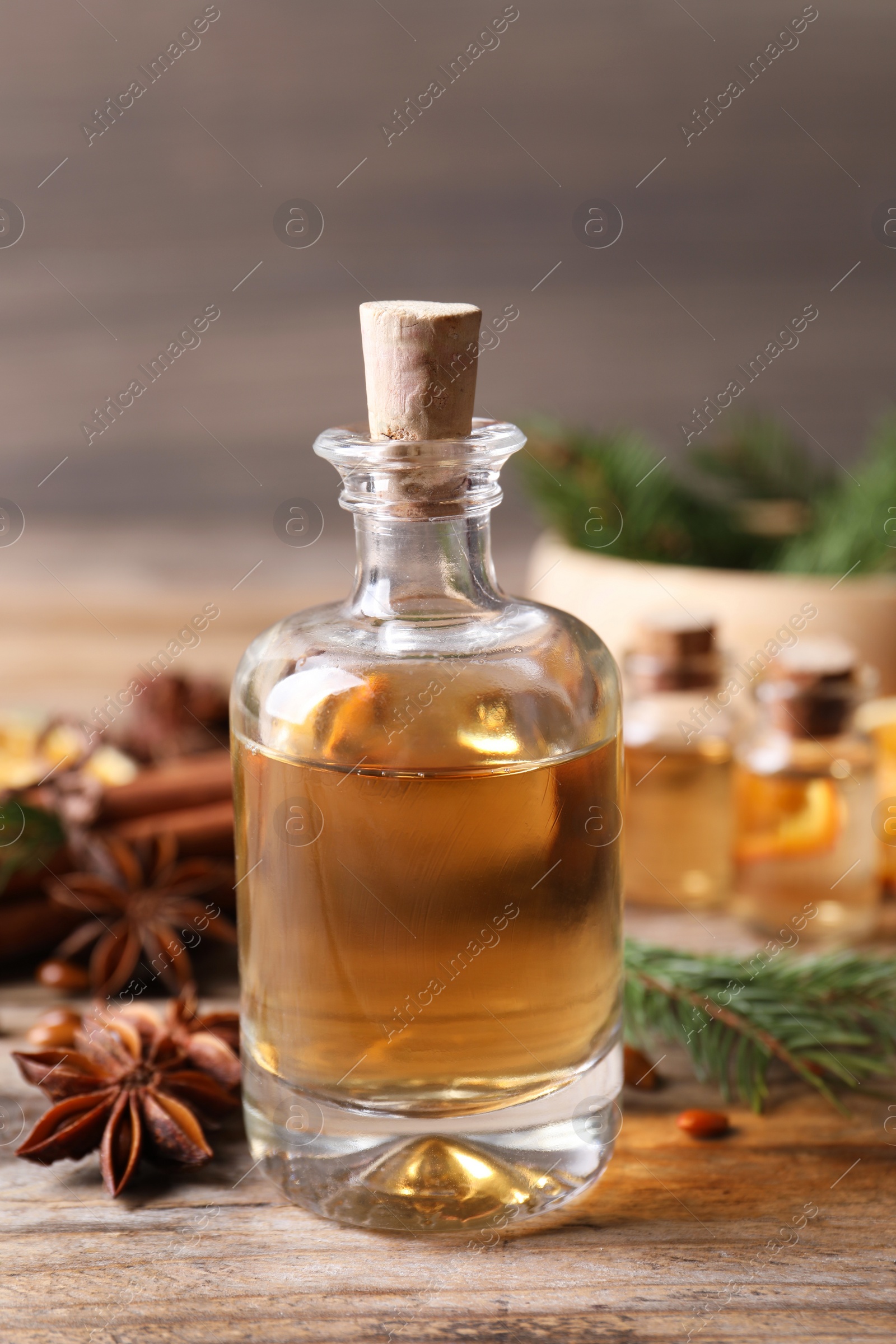 Photo of Anise essential oil and spice on wooden table