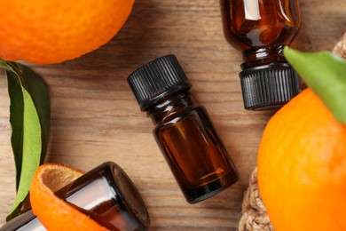 Flat lay composition with tangerine essential oil on wooden table