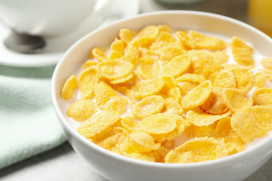 Photo of Tasty corn flakes with milk on table, closeup