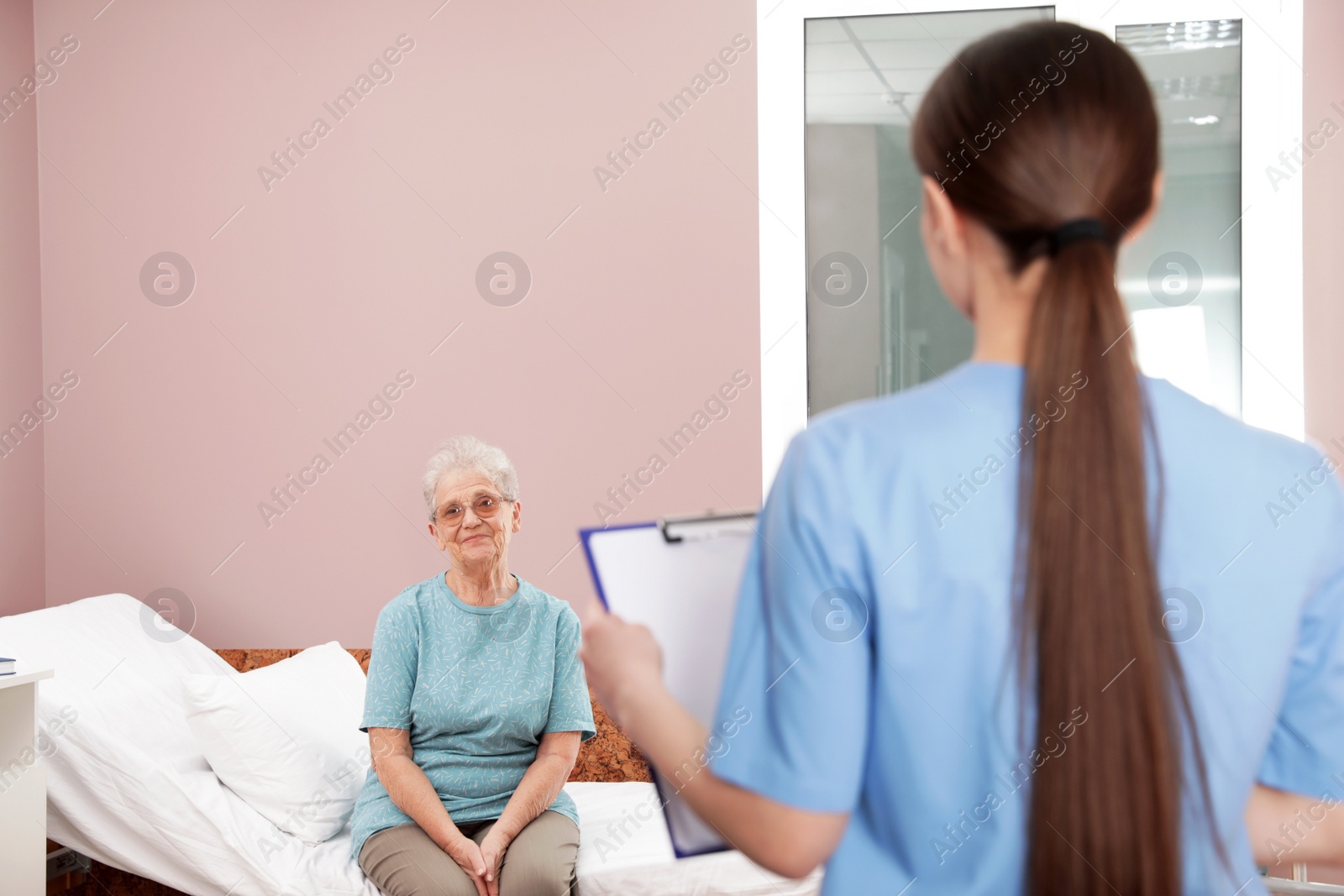 Photo of Senior patient and nurse in hospital ward. Medical assisting