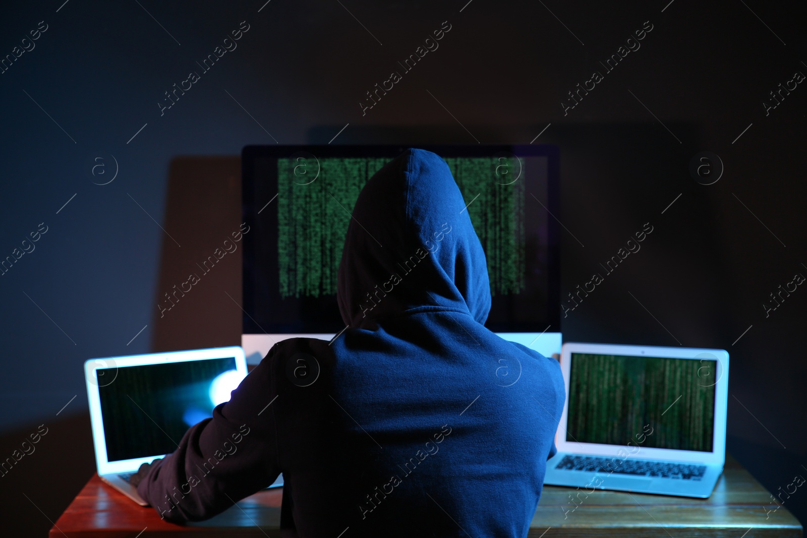 Photo of Hacker with computers in dark room. Cyber crime