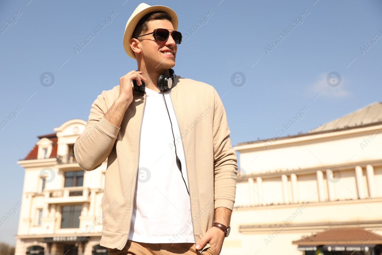 Photo of Happy man with headphones on city street