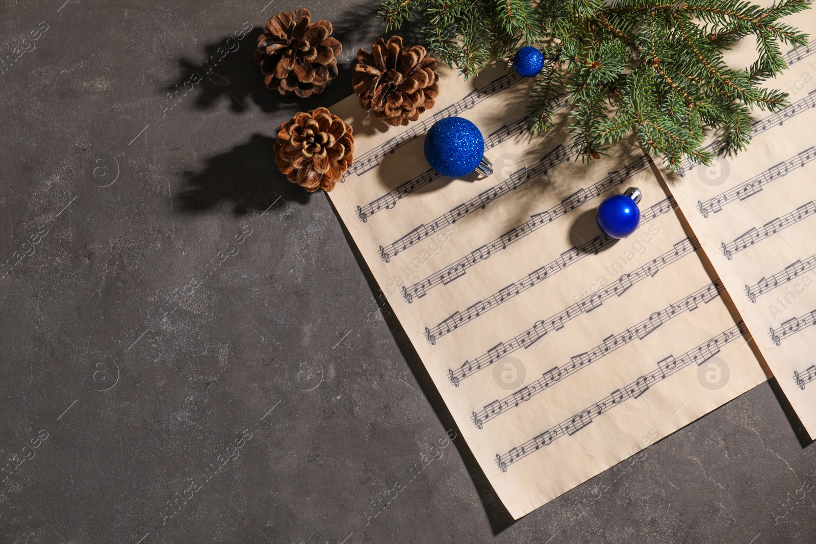 Photo of Composition with Christmas balls and music sheets on grey background, top view. Space for text
