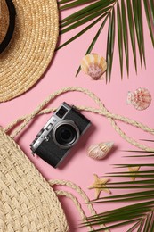 Flat lay composition with beach bag and camera on pink background