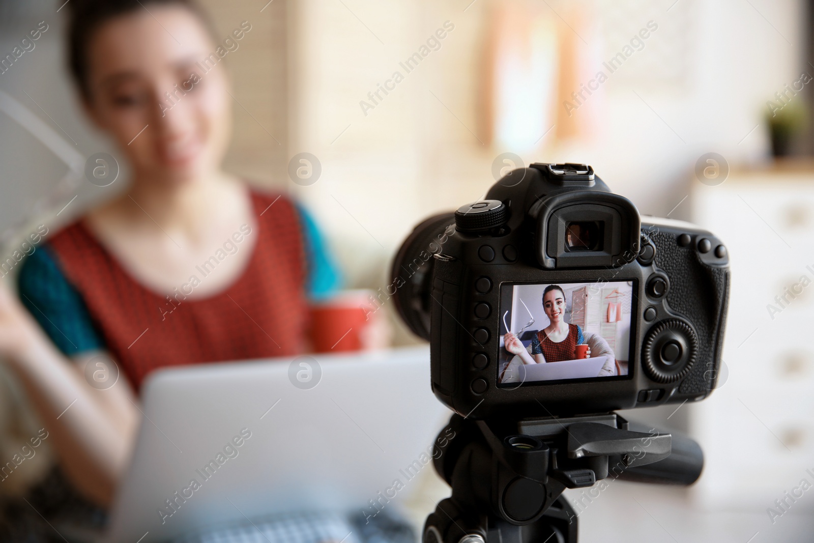 Photo of Female blogger with laptop on camera screen, closeup