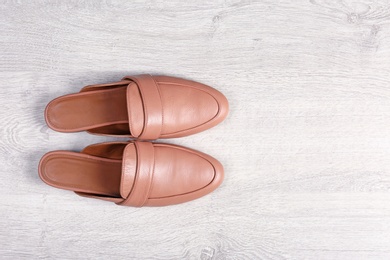 Photo of Pair of female shoes on wooden background, top view