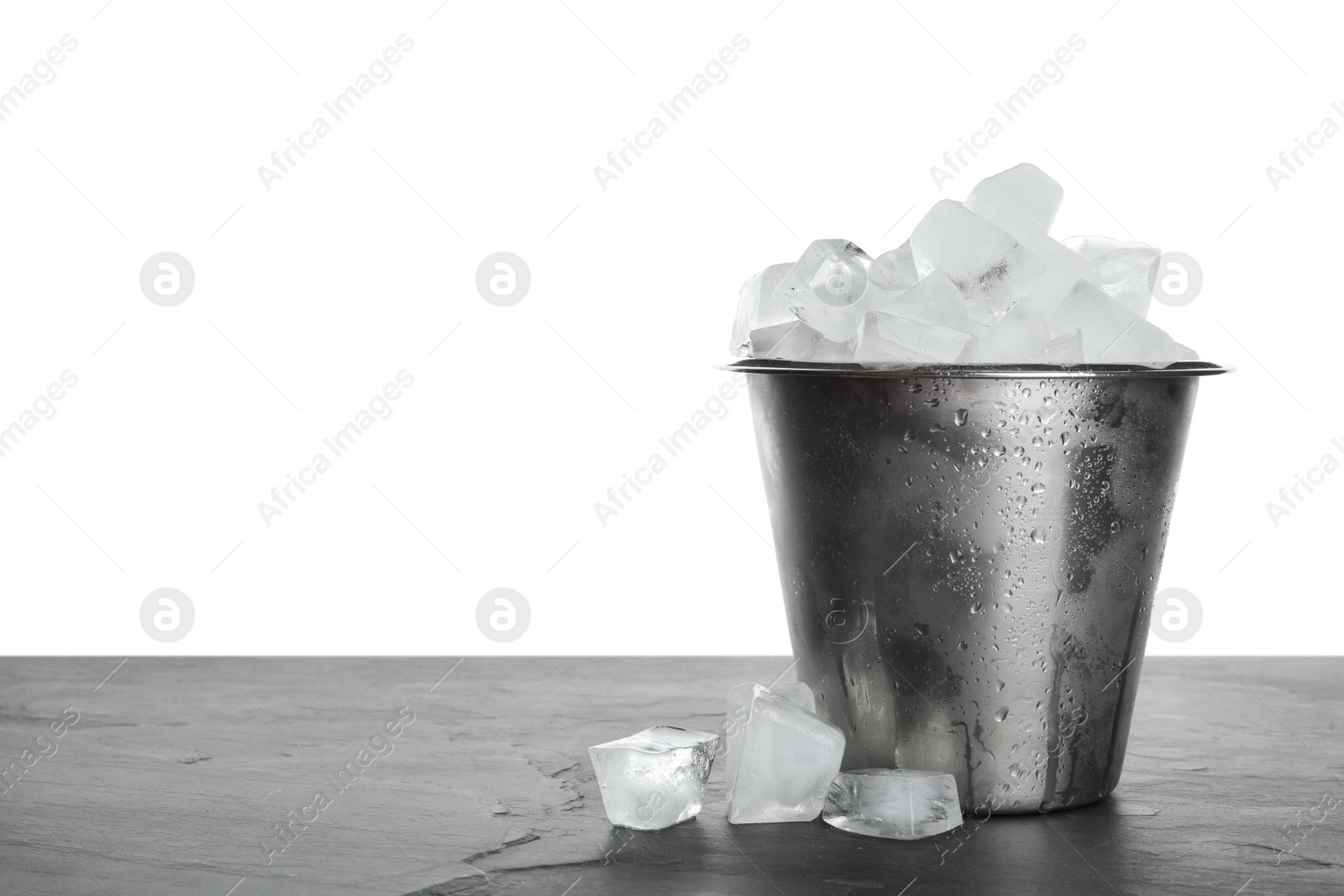 Photo of Metal bucket with ice cubes on table against white background