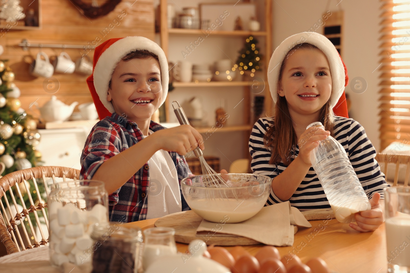 Photo of Cute little children making dough for Christmas cookies at home