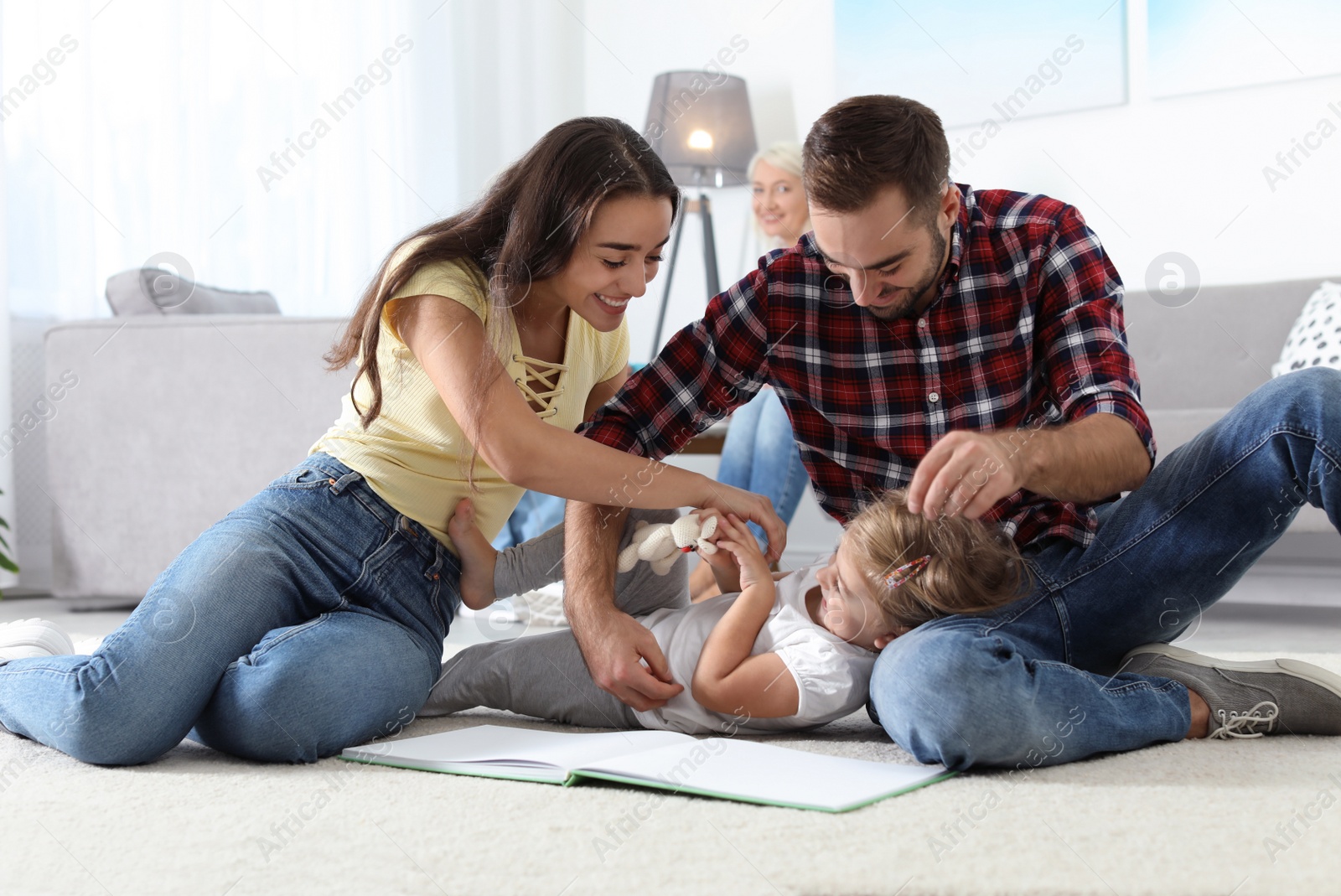 Photo of Young couple spending time with their daughter at home. Happy family