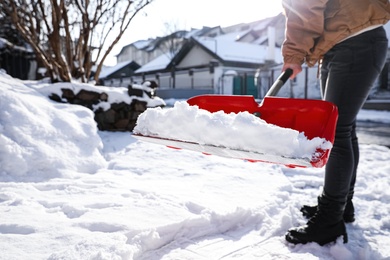 Photo of Person shoveling snow outdoors on winter day, closeup