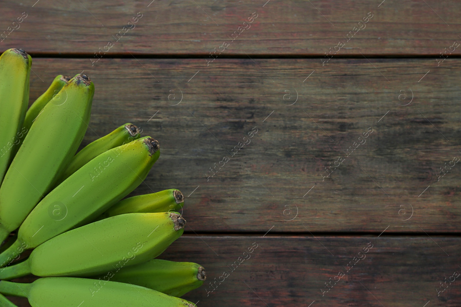 Photo of Bunch of delicious bananas on wooden table, top view. Space for text