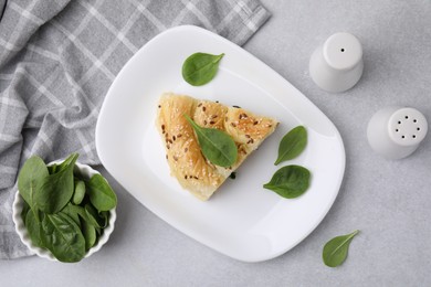 Photo of Piece of delicious puff pastry with spinach on light table, flat lay