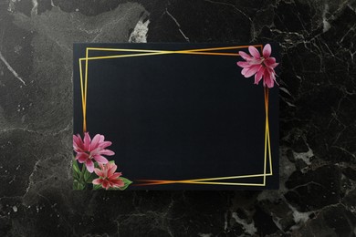 Photo of Blank invitation card on black marble background, top view. Space for text