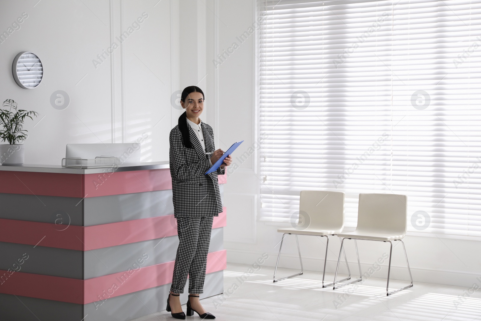 Photo of Receptionist with clipboard near countertop in office, space for text