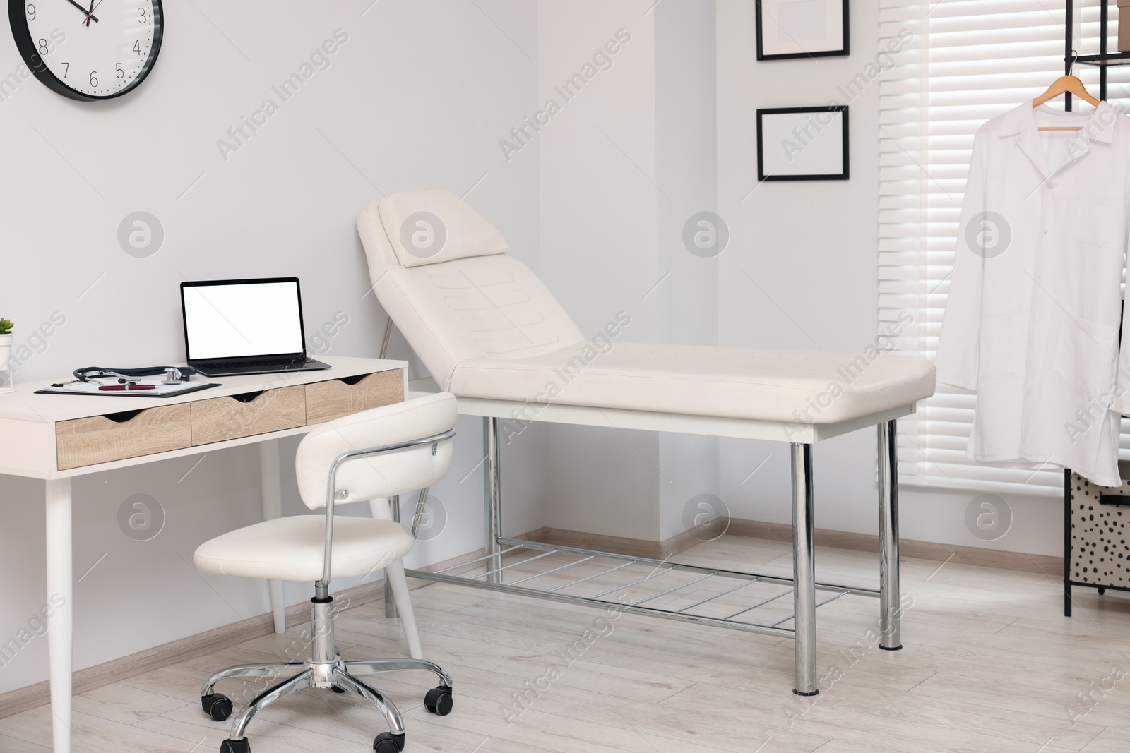 Photo of Modern medical office with doctor's workplace and examination table in clinic