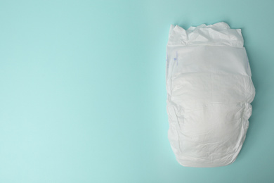 Photo of Baby diaper on light blue background, top view. Space for text