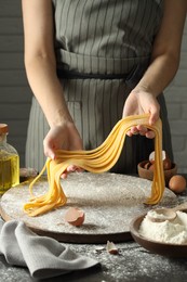 Photo of Woman making homemade pasta at table, closeup