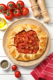 Flat lay composition with tasty tomato galette (Caprese galette) on white wooden table