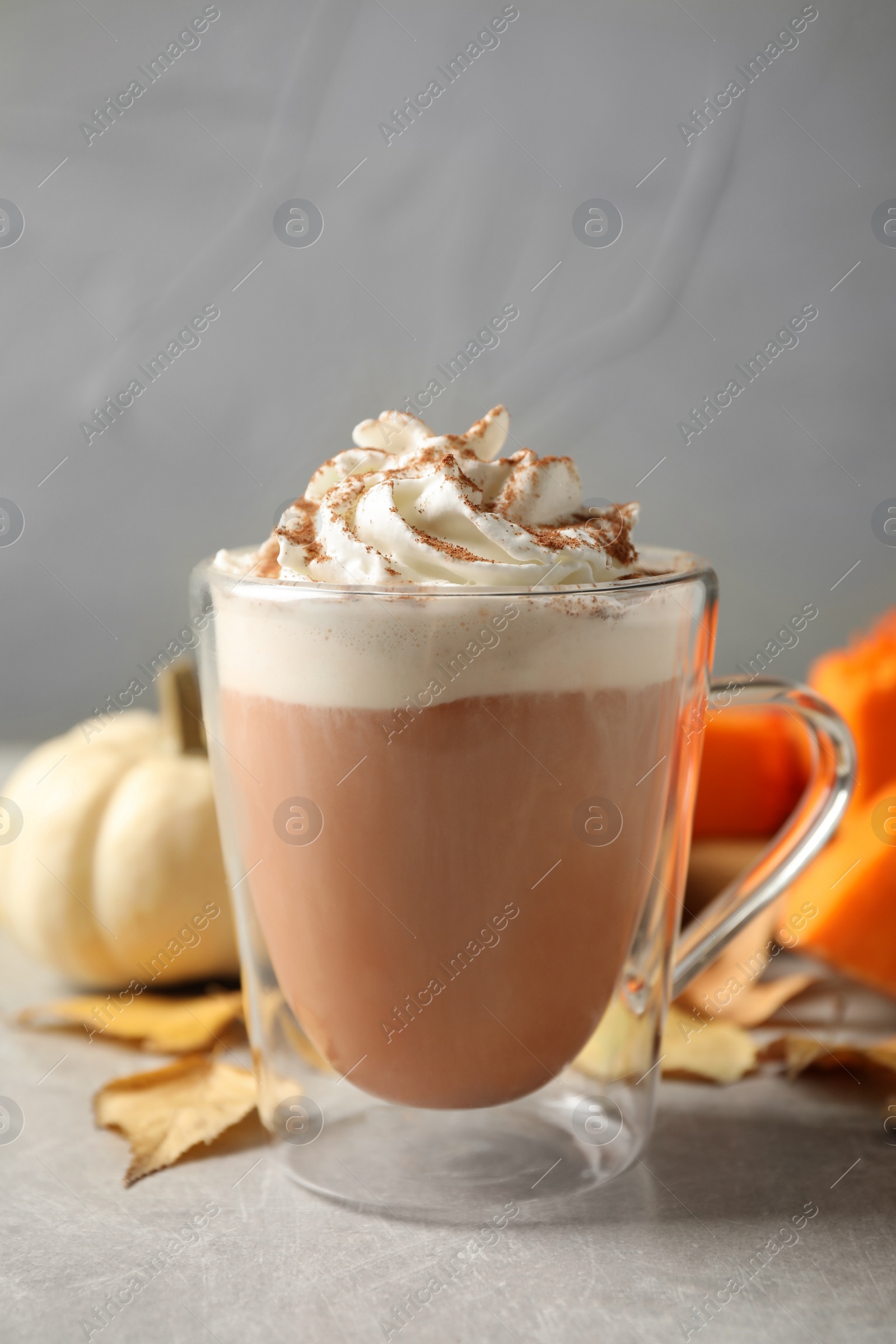 Photo of Delicious pumpkin latte on grey table, closeup