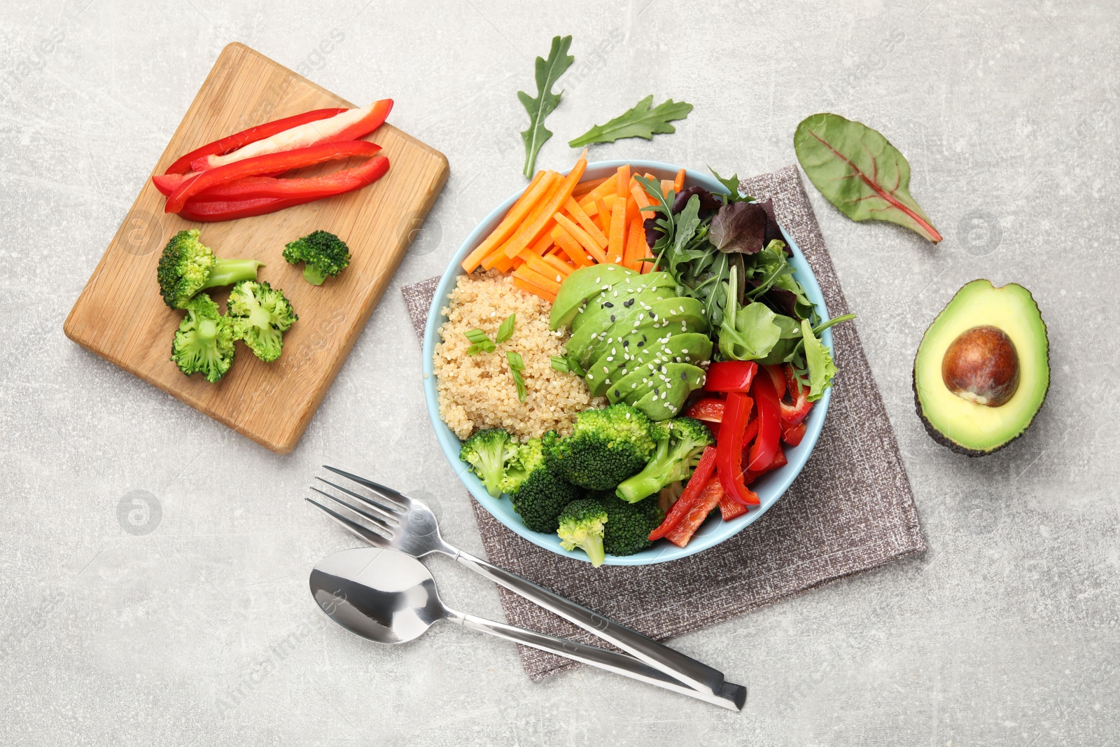 Photo of Delicious vegan bowl with bell peppers, avocados and broccoli on grey table, flat lay