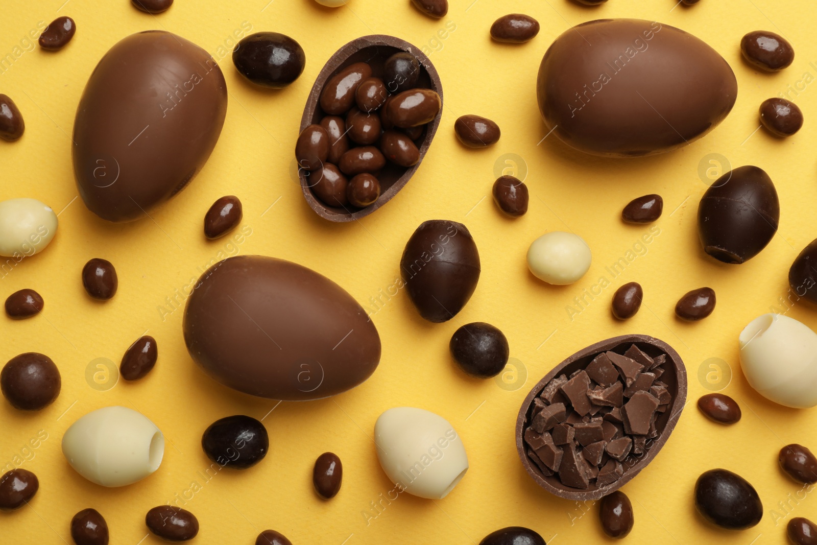 Photo of Flat lay composition with chocolate Easter eggs on color background