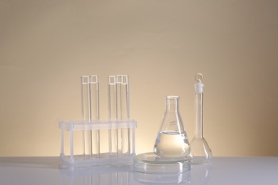 Photo of Laboratory analysis. Different glassware on table against beige background