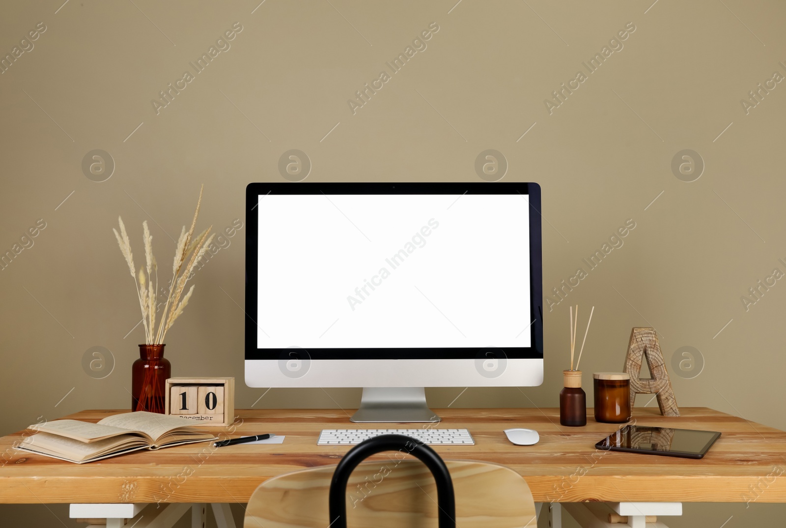 Photo of Modern computer and decor on wooden table near beige wall