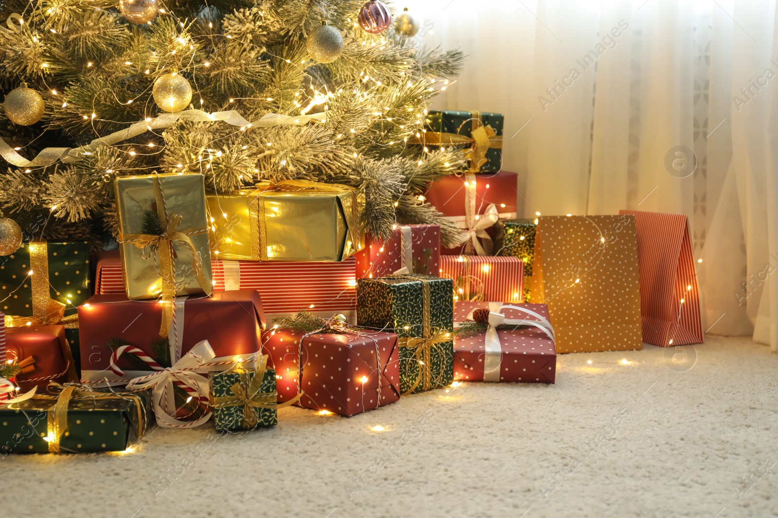 Photo of Many different gifts under Christmas tree indoors