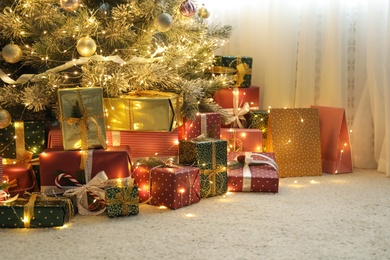 Many different gifts under Christmas tree indoors