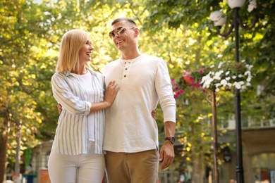 Photo of Happy couple walking along park on summer day