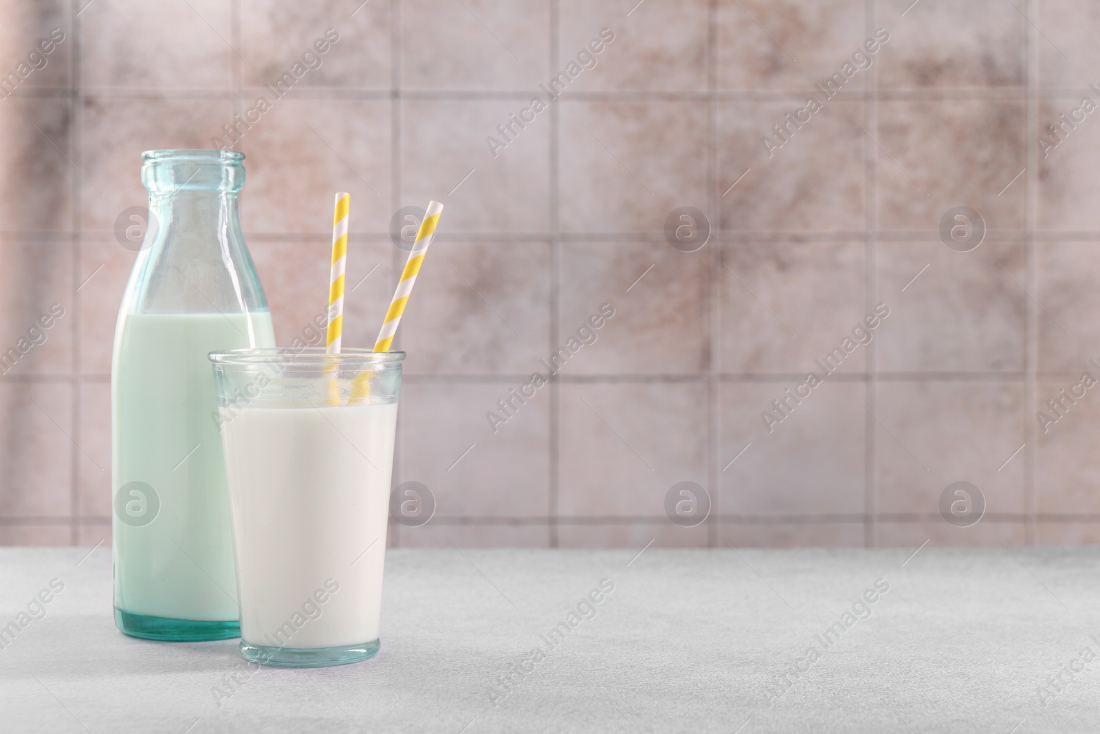 Photo of Glassware with tasty milk on light gray table, space for text