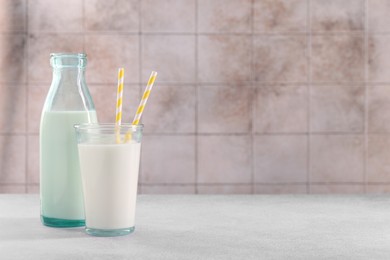 Photo of Glassware with tasty milk on light gray table, space for text