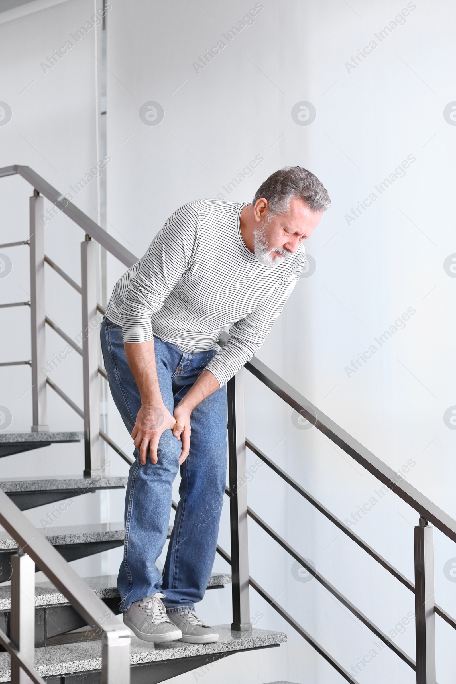 Photo of Senior man suffering from knee pain indoors