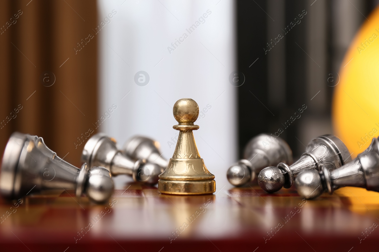 Photo of Pawn piece among defeated ones on chessboard indoors