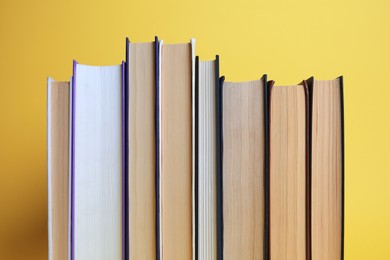 Collection of hardcover books on yellow background