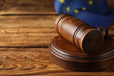 Judge's gavel and European Union flag on wooden table, closeup. Space for text