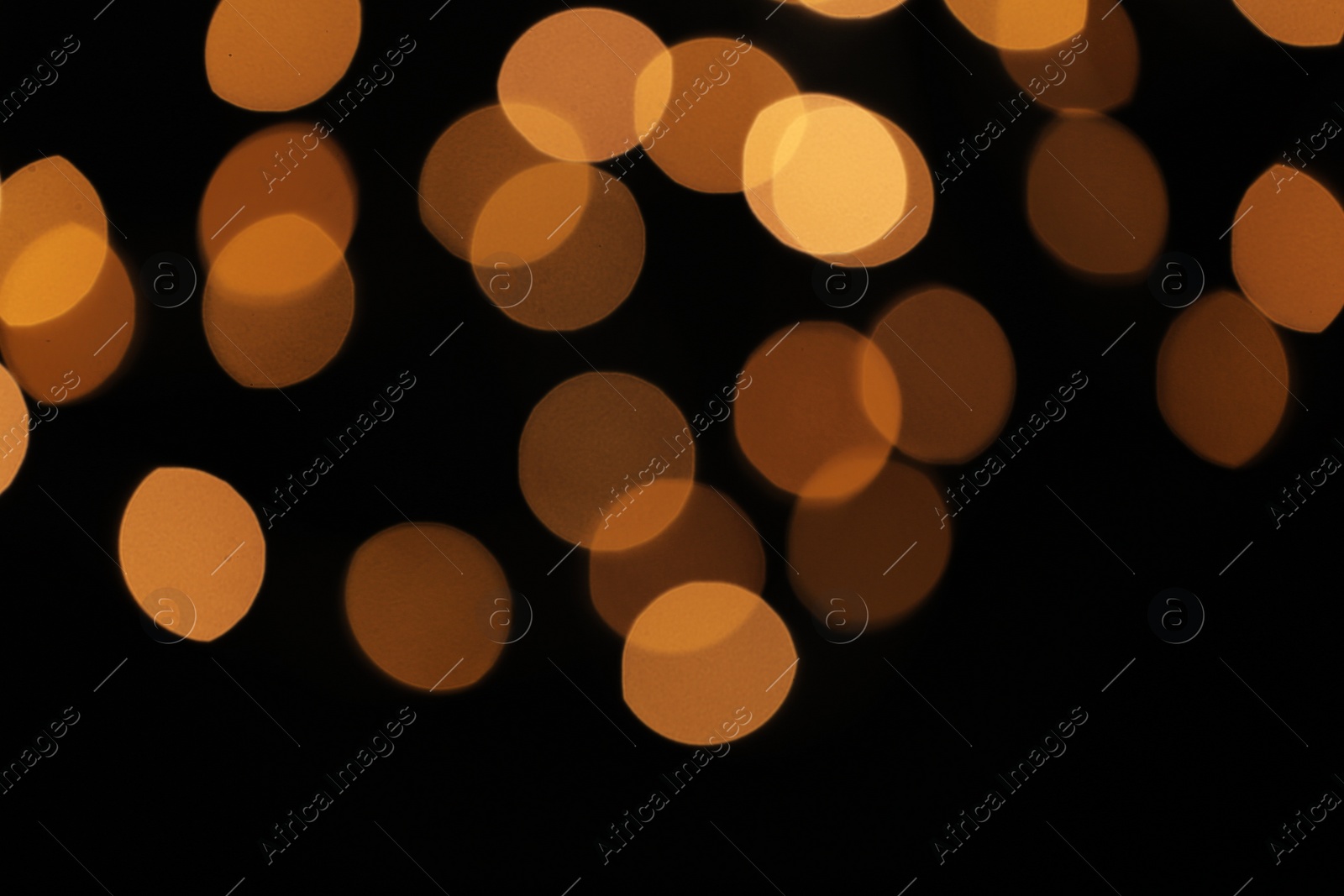 Photo of Blurred view of festive lights on dark background. Bokeh effect