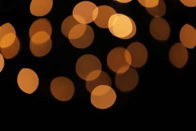 Photo of Blurred view of festive lights on dark background. Bokeh effect