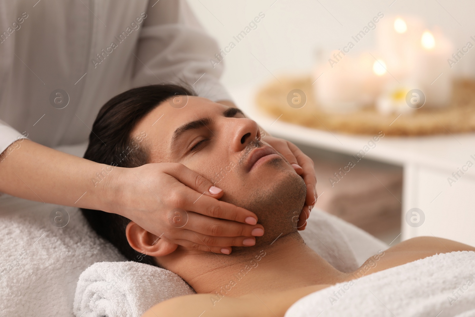 Photo of Man receiving facial massage in beauty salon