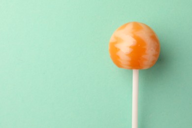 Tasty lollipop on turquoise background, top view. Space for text