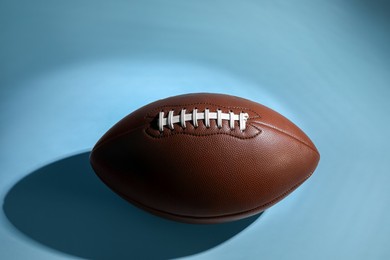 Photo of American football ball on light blue background