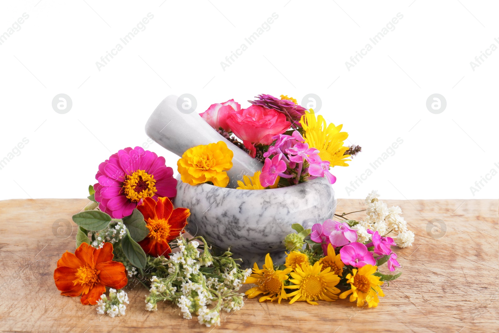 Photo of Marble mortar, pestle and different flowers on wooden table against white background