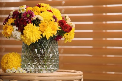 Photo of Bouquet of beautiful chrysanthemum flowers on wicker table near window indoors, space for text