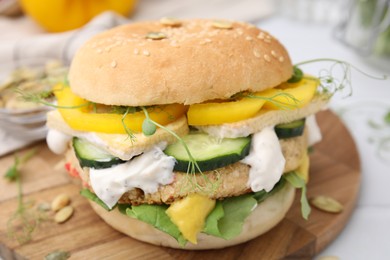 Photo of Tasty vegan burger with vegetables, sauce and patty on white table, closeup