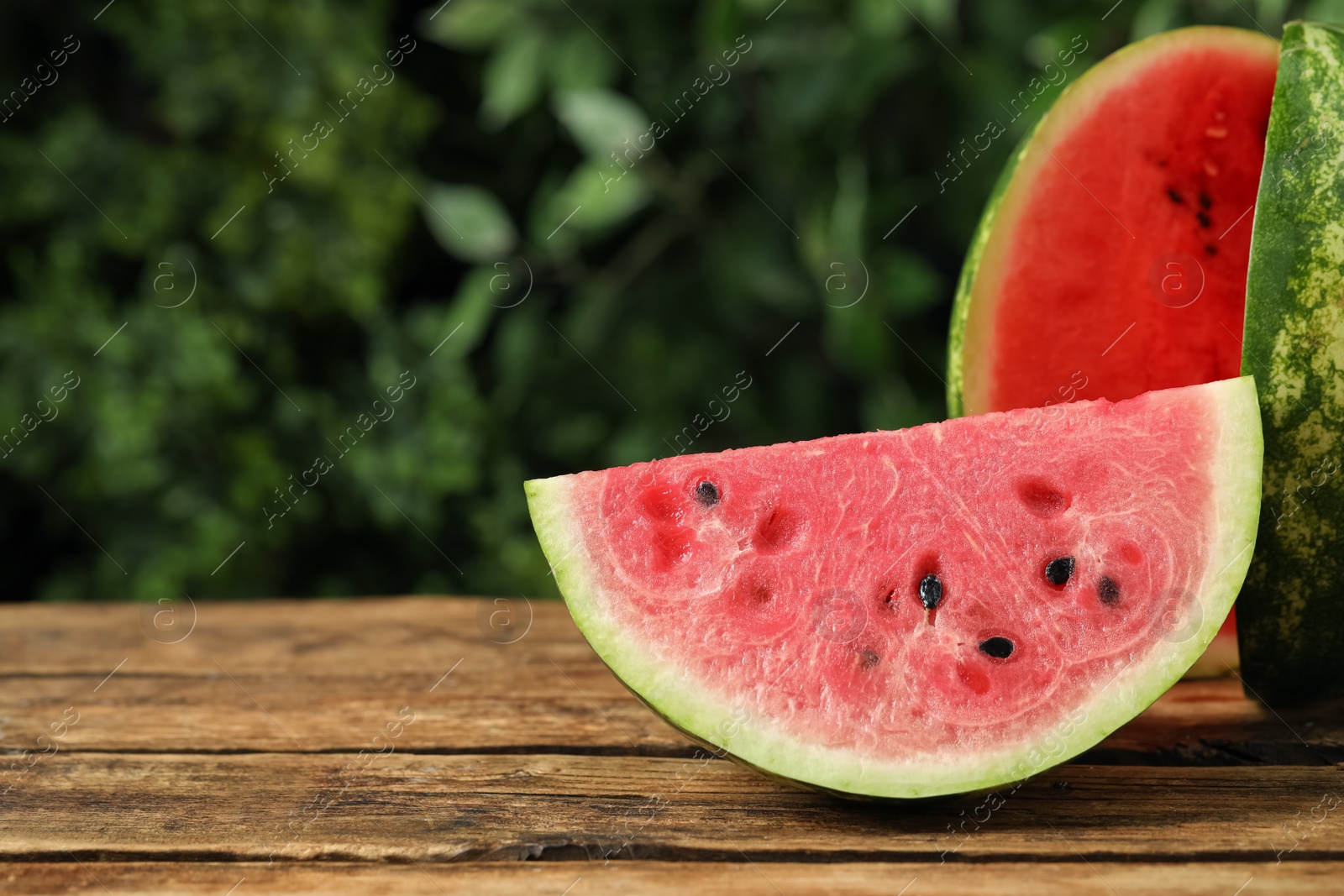 Photo of Delicious fresh watermelon slices on wooden table. Space for text