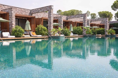 Outdoor swimming pool with umbrellas and sunbeds at resort