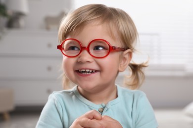 Photo of Cute little girl in glasses at home